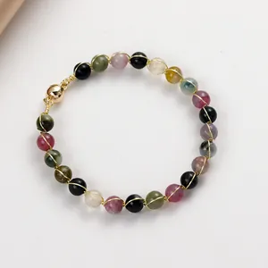Detailed view of tourmaline magnetic bracelet with 14K gold wire wrap detail.