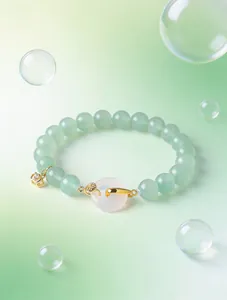 Detail of natural pink crystal and green agate beaded bracelet with gold safety buckle