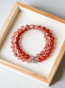 Detail view of natural red phantom quartz and agate beaded bracelets in a wood box