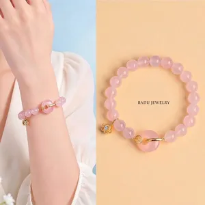 Elegant natural rose quartz beaded bracelet featuring a peace buckle and a gold flower charm