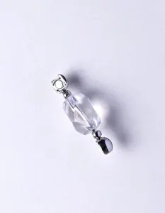 Detailed macro view of a clear faceted crystal bead with silver-toned metal connectors