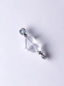 Detailed view of clear heart-shaped natural crystal bead with polished silver metal accents