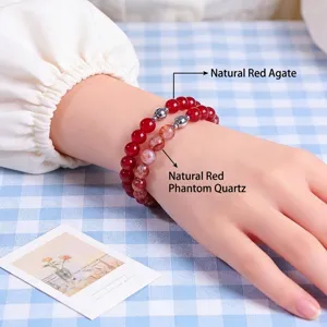 Natural red agate and phantom quartz beaded bracelet worn on wrist over checkered background