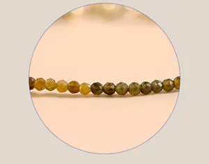 Macro view of 2mm faceted yellow tourmaline gemstone beads on a delicate jewelry bracelet