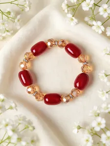 Detailansicht eines eleganten Armbands mit roten Achatperlen und gelben Kristallen