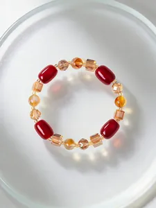 Nahaufnahme eines eleganten Armbands mit rotem Achat und gelben Kristallperlen.