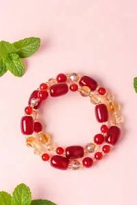 Nahaufnahme der glänzenden roten Achat-Fassperlen und des gelben Kristallarmbandes