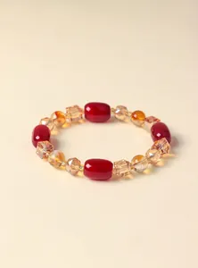 Nahaufnahme von roten Achatperlen und gelben Kristallperlen an einem stilvollen Armband.