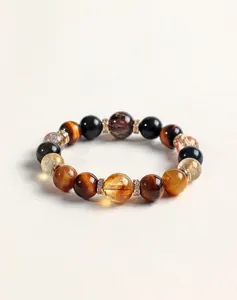 Vista macro de pulsera de cuentas de varias piedras con ojo de tigre, cuarzo y cuentas doradas