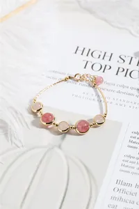 Detail shot of strawberry and rose quartz beaded bracelet with 14k gold plating