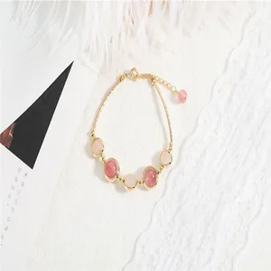 Close-up detail of rose and strawberry quartz beaded bracelet with gold-plated links