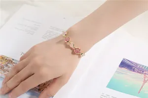 Detailed close-up view of pink strawberry quartz beaded bracelet on a woman's wrist