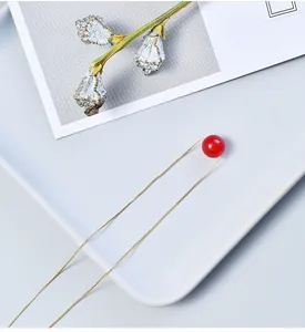 Minimalist gold chain necklace featuring a round red strawberry crystal pendant detail.