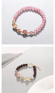 Detail shot of garnet and strawberry quartz beaded bracelets with 14K gold-plated accents.