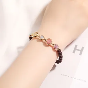 Elegant garnet and multicolor crystal bracelet with 14k gold filled beads on wrist.