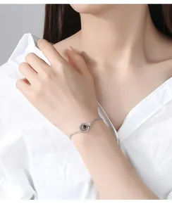 Detail of platinum plated memory of love bracelet on wrist with projection stone