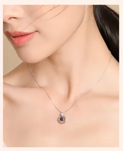 Detail view of a model wearing a minimalist white gold plated projection necklace