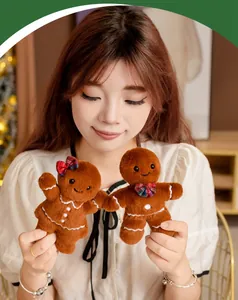 Modell hält zwei süße Lebkuchenmann-Plüschpuppen, ideal für Weihnachtsgeschenke