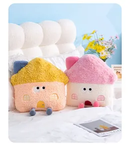 Nahaufnahme von niedlichen 2-in-1 Plüschkissen in Hausform auf einem weißen Bett