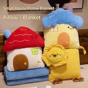 Detalle del conjunto de almohada y manta 2 en 1 con forma de casa de dibujos animados.