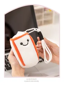 Detailed close-up of a cute plush boxing sandbag pendant with a smile held in hands.