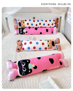 Long cat and bear body pillows arranged on a bed in a cozy bedroom setting