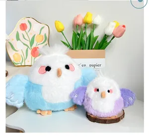 Close-up of soft plush milk ball bird toy dolls in blue and purple pastel colors.
