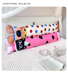 Two cute dopamine cat and bear long cylindrical bolster pillows on a cozy white bed