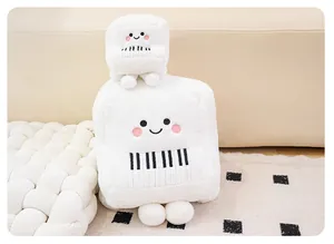 Two cute white plush piano toys stacked in a cozy home setting with soft lighting
