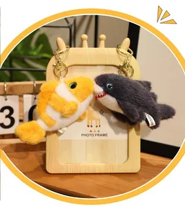 Close-up detail of cute orange clownfish and grey shark plush animal keychains hanging