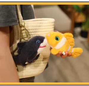 Close-up of cute shark and clownfish plush keychain charms on a straw tote bag