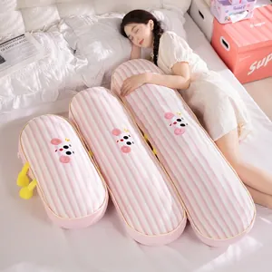 Detailed view of three pink striped leg pillows in different sizes on a bed.