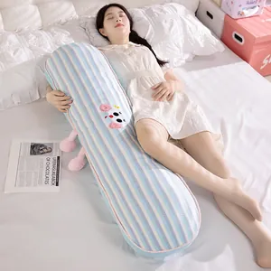 Detail view of a model hugging a blue striped ice silk body pillow on a white bed