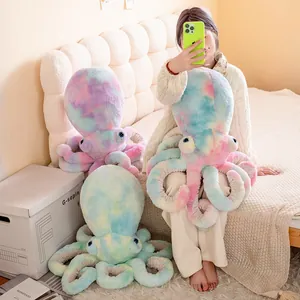 Vista dettagliata di peluche a forma di polpo tie-dye colorati in una camera da letto accogliente