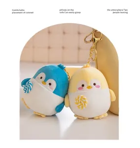 Close-up of cute penguin plush keychains with lollipop accessories and golden clips