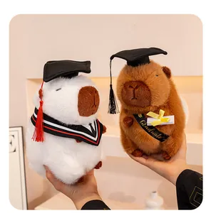 Primo piano di simpatici peluche di capibara che indossano tocchi da laureato in miniatura