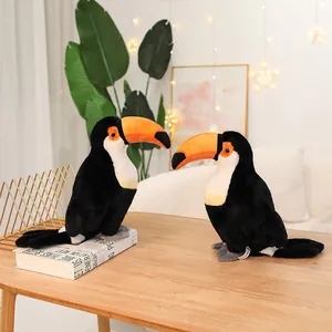 Two lifelike Toucan plush bird toys displayed on a wooden table in a cozy home setting.