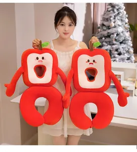 Asian model holding cute red apple-shaped cartoon plush nap pillows in a cozy room