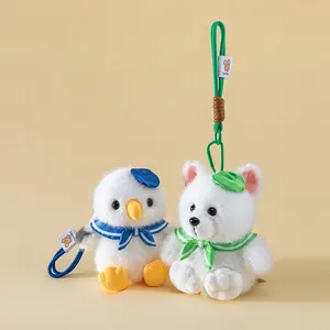 Detail of cute white seagull and polar fox plush toy pendants with sailor accessories