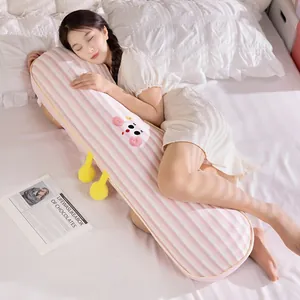 Asian woman hugging a long striped pink body pillow for side sleeping comfort on bed.