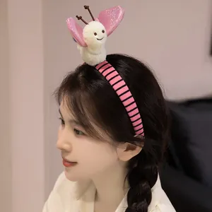 Serre-tête papillon en peluche mignon porté par un modèle avec des accents rose doux