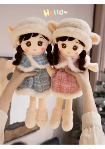 Nahaufnahme von zwei süßen Plüschpuppen in blau-rosa Tweed-Kleidern, ideal als Kindergeschenk