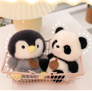 Detailansicht von flauschigen Panda- und Pinguin-Plüschpuppen in einem rosa Metallkorb