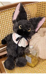 Detailaufnahme einer lockigen schwarzen Plüschkatze mit weißem Schleifenhalsband