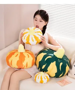 Detailaufnahme von bunten Kürbis-Plüschkissen, die ein Model auf einem Sofa hält