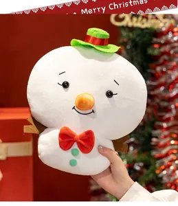 Primo piano di un pupazzo di neve di peluche con cappello verde e fiocco rosso