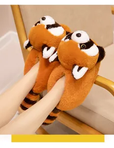 Close-up van schattige oranje rode panda pluche pantoffels op een houten stoel in de kamer