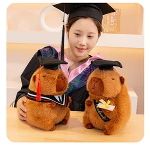 Due adorabili peluche capybara con tocco e toga da laureato, regalo creativo per studenti.
