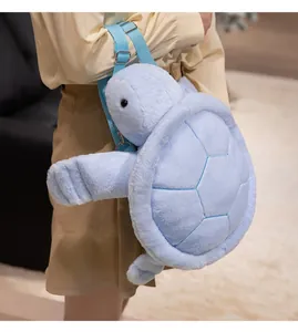 Detail view of a soft light blue plush turtle backpack worn on a model's back in a cozy room