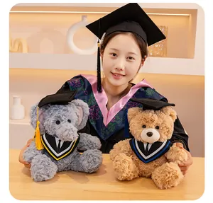 Dettaglio di peluche di laurea a forma di orso ed elefante tenuti da una studentessa.